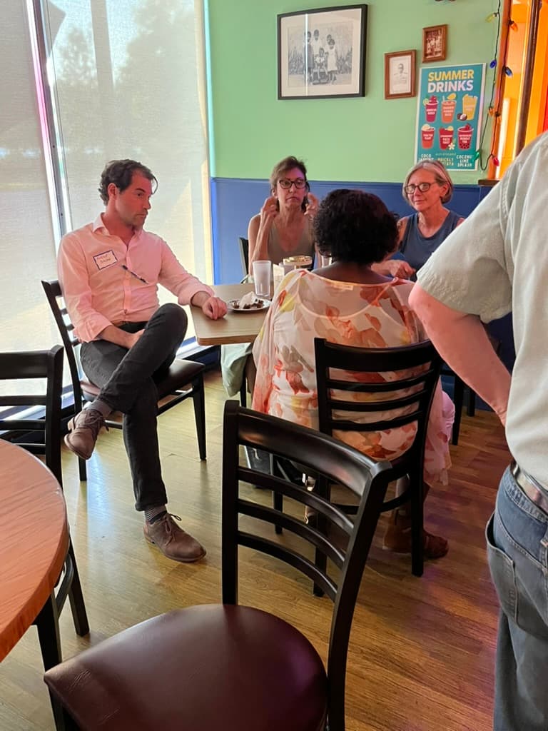 Mike Sacks listening to constituents at local cafe discussing issues affecting NY-17 working families