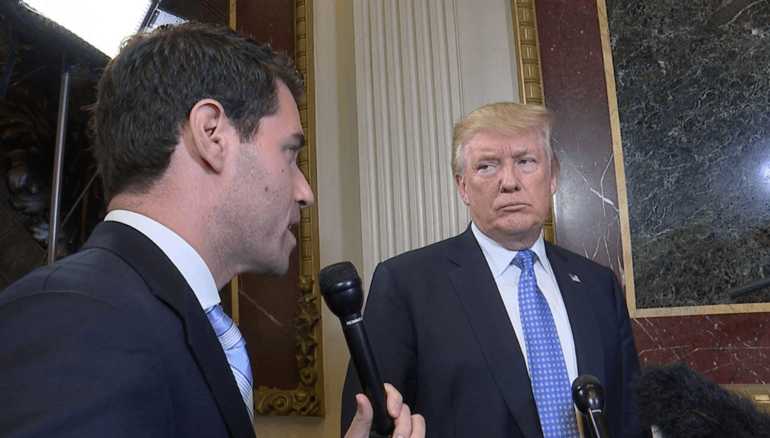 Mike Sacks interviewing with microphone questioning Trump